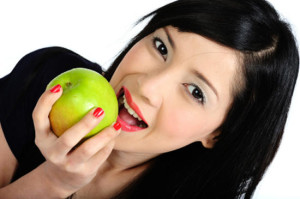 Young asian girl eating apple